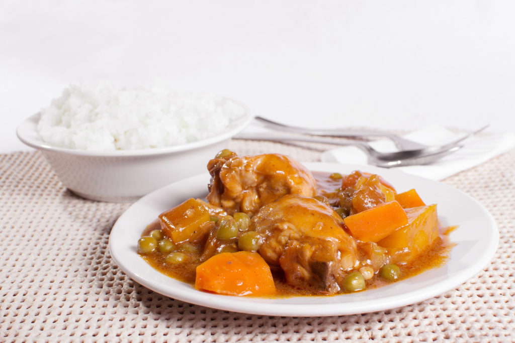 chicken afritada with bowl of rice