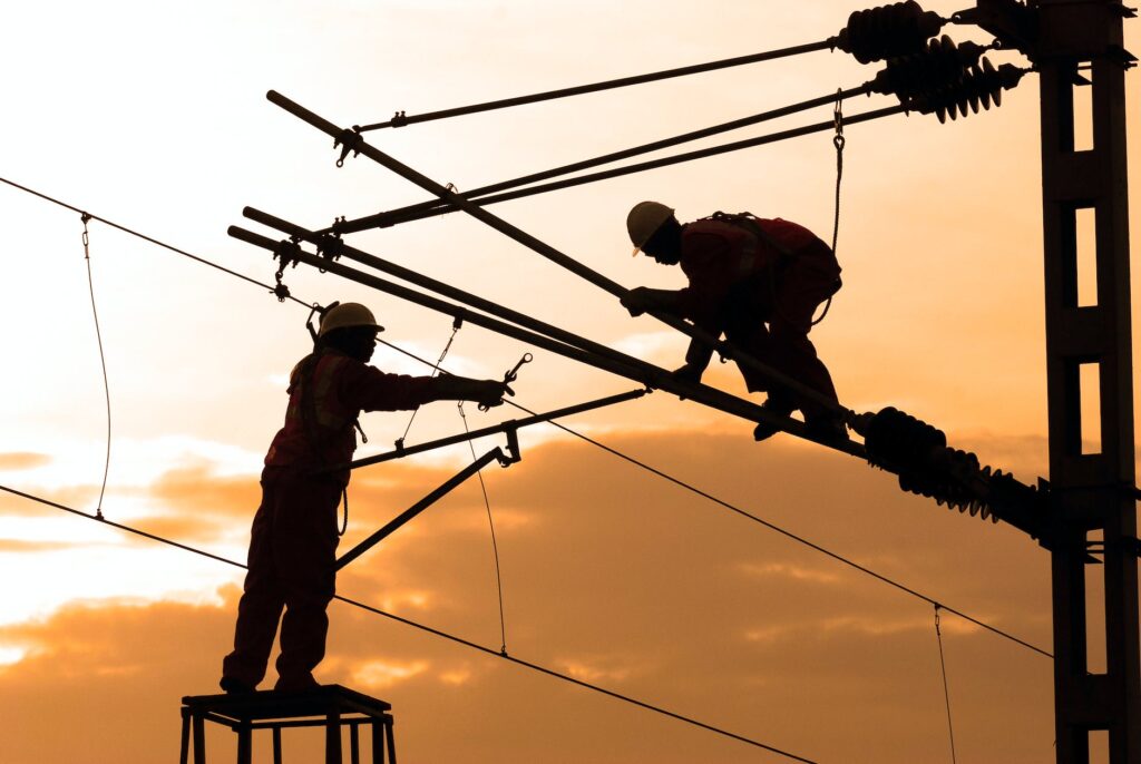 silhouette of two electricians working